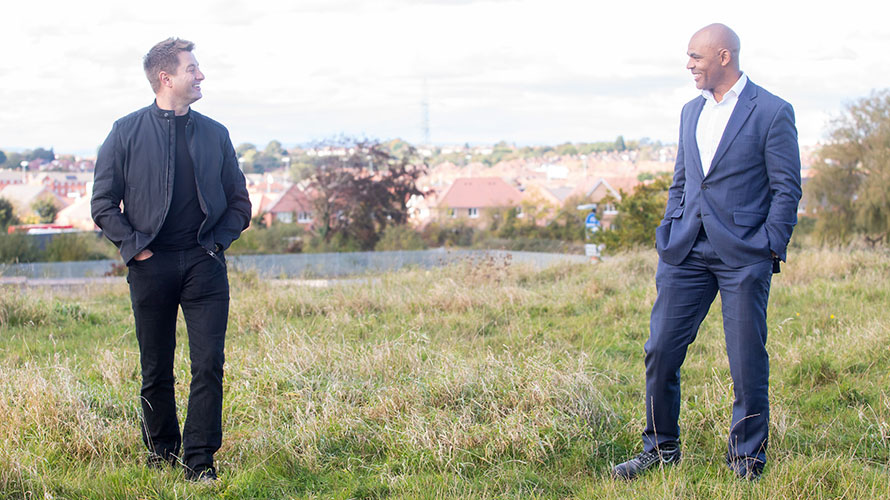 George and Marvin talking on grass.